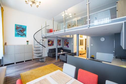 ein offenes Wohnzimmer und ein Esszimmer mit einer Treppe in der Unterkunft Budapest Kálvin Apartman 2020 in Budapest