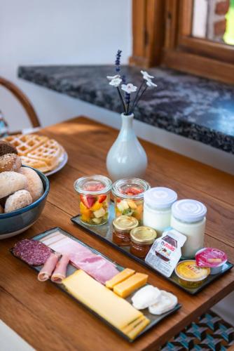 a table with cheese and other food items on it at Boutique hotel Shamon in Eeklo