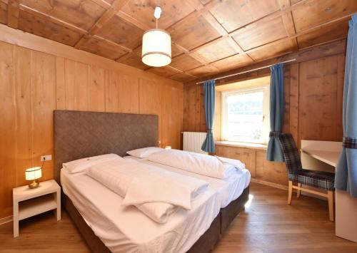 a bedroom with a large bed in a wooden room at Casa Dorich in Pozza di Fassa