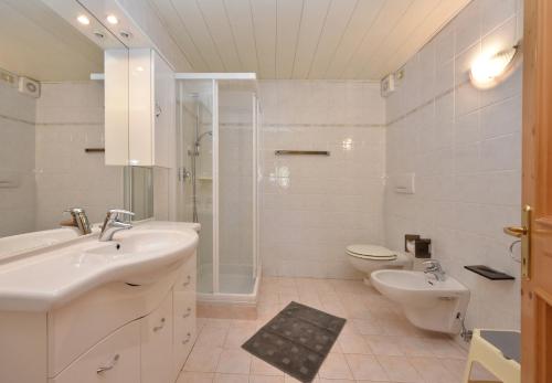 y baño con lavabo, aseo y ducha. en Casa Dorich en Pozza di Fassa