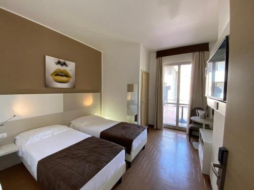 a hotel room with two beds and a window at Hotel Ristorante Novara Expo in Bareggio
