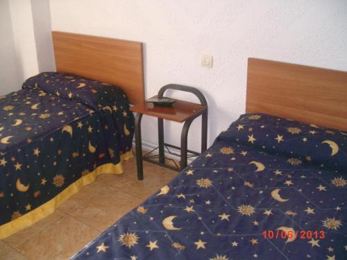 カラタユーにあるPensión Santa Martaのベッド2台、テーブル、デスクが備わる客室です。
