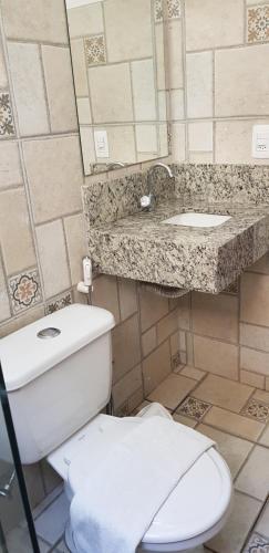 a bathroom with a toilet and a sink at Hotel Uirapuru in Alexânia