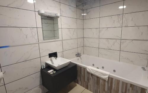 a bathroom with a sink and a bath tub at Gilson Hotel in Hull