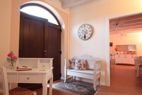 a living room with a table and a clock on the wall at Il Conte in San Bonifacio