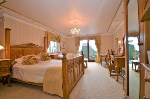 a bedroom with a large bed and a desk at Koala Cottage in Ventnor