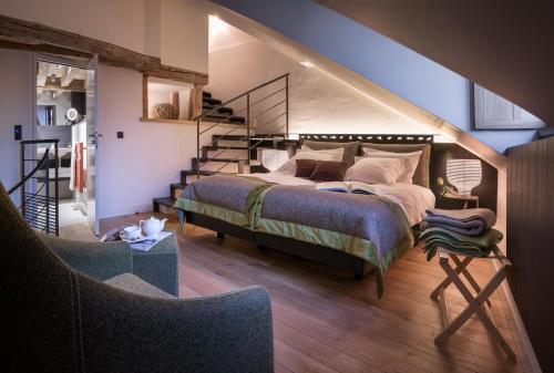 a bedroom with a large bed and a staircase at Les Loges Annecy Vieille Ville in Annecy