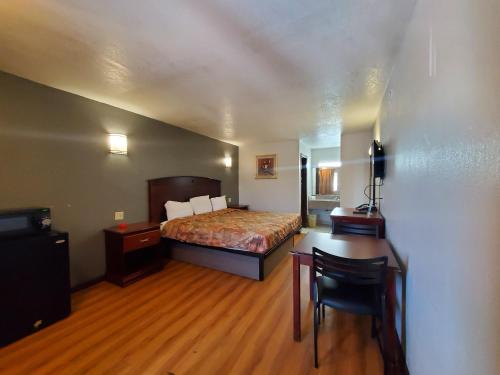 a bedroom with a bed and a desk and a table at Welcome Inn in Dallas