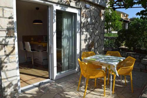 a patio with a table and chairs on a patio at Apartments Eta in Cres