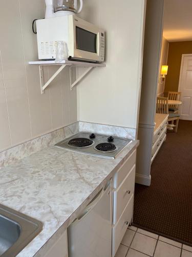 
a kitchen with a microwave and a sink at The Admiral Hotel/Motel in Ocean City
