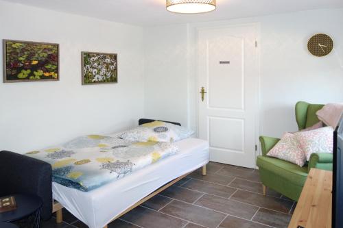ein Schlafzimmer mit einem Bett und einem grünen Stuhl in der Unterkunft Das Kartenhaus in Saarburg