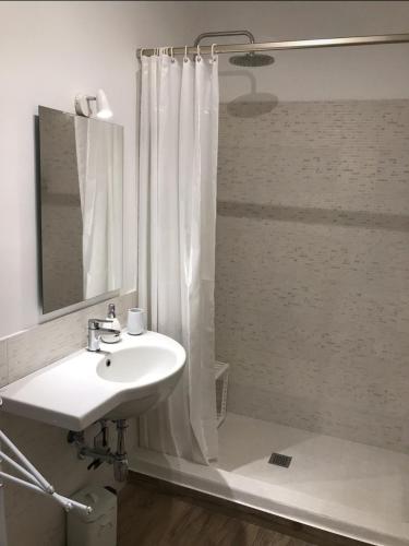 a white bathroom with a sink and a shower at Le Dimore della Villa dei Sogni in Vulcano