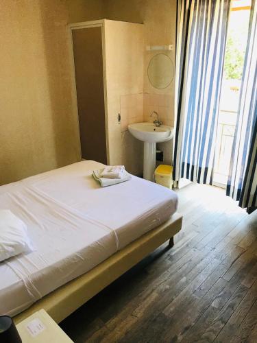 Ce lit se trouve dans un dortoir doté d'un lavabo et d'une sidx. dans l'établissement hotel de la gare, à Verchamp