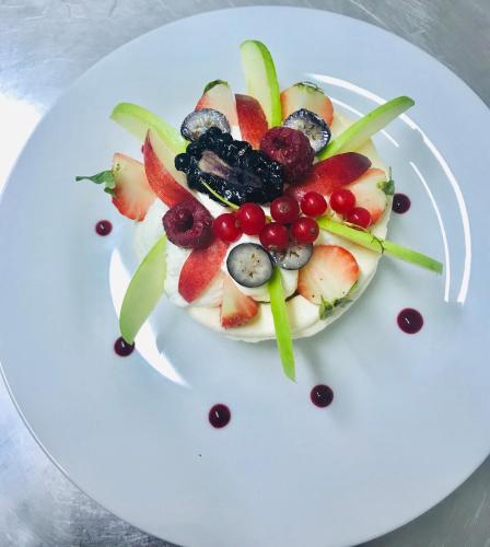 une assiette blanche accompagnée d'une salade de fruits dans l'établissement hotel de la gare, à Verchamp