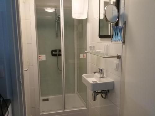 La salle de bains est pourvue d'une douche et d'un lavabo. dans l'établissement De Strandgaper, à Zevenhuizen