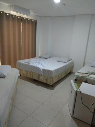 a room with two beds and a window in it at Ágape Hotel De Aparecida in Aparecida