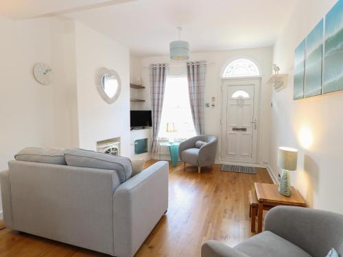 a living room with a couch and a chair at Gull's Nest in Lowestoft