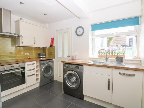 a kitchen with a washing machine and a sink at Gull's Nest in Lowestoft