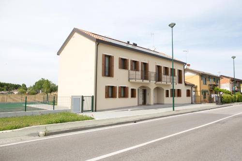 a white building on the side of a street at Venezia Fly Apartments in Tessera