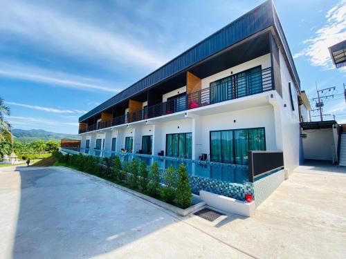 a building with a swimming pool in front of it at Belong Jin The Dam Hotel And Resort in Ban Pha Saeng Lang