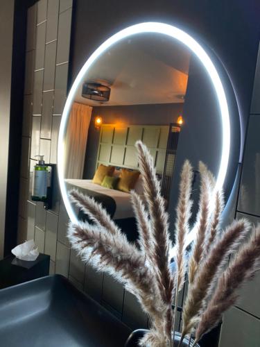 a mirror in a bathroom with a bed and a plant at The Baltic Hotel in Liverpool