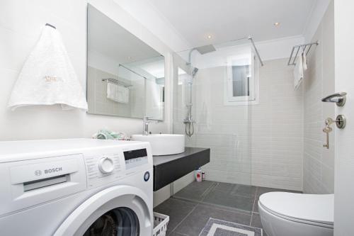 メソギーにあるAthena Luxury Apartmentsの白いバスルーム(洗濯機付)