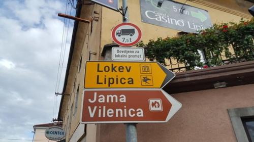 a group of signs on a pole in front of a building at HOSTEL-SezanaLOKEV B&B in Sežana