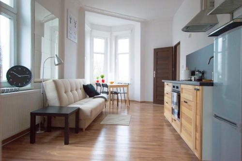 ein Wohnzimmer mit einem Sofa und einer Küche in der Unterkunft Herman View Apartment in Graudenz