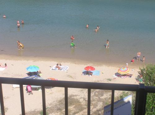 a group of people on the beach in the water at Mira-mar in Odeceixe