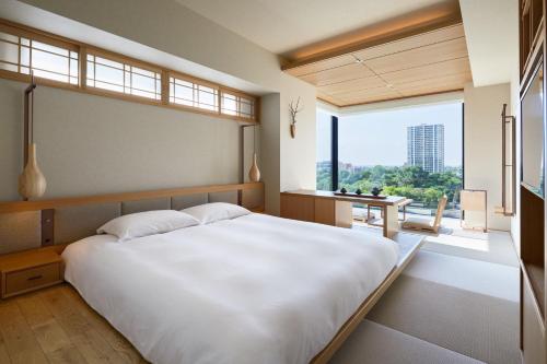 a bedroom with a large white bed and a large window at ONSEN RYOKAN Yuen Sapporo in Sapporo