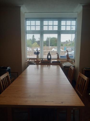 a large wooden table in a room with a large window at BELLEVILLE BED AND BREAKFAST in Elgin