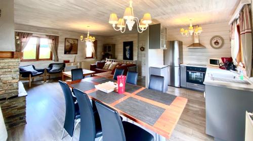 eine Küche und ein Wohnzimmer mit einem Holztisch und Stühlen in der Unterkunft Chalet Ardenne Routy in Rochehaut