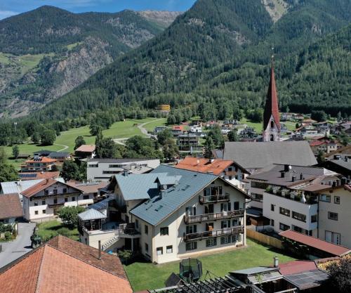 an aerial view of a town with a church and mountains at Marbergerhaus Umhausen in Umhausen