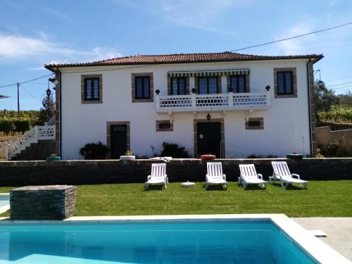 una casa con piscina frente a una casa en Solar dos Avós en Sabrosa