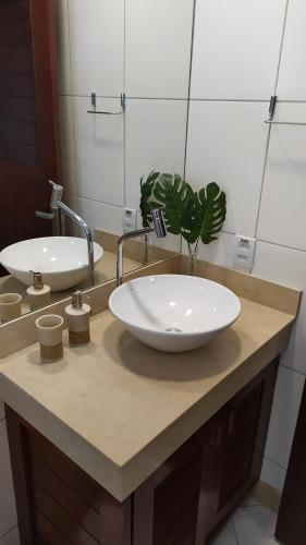a bathroom with two sinks and a plant on a counter at Apartamento na Praia do Amor-Pipa in Pipa