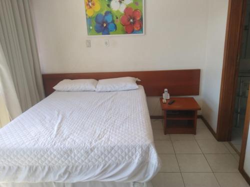 una camera da letto con un letto bianco e un tavolo di Barra Summer flat a Salvador