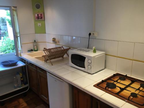 a kitchen with a microwave sitting on a counter at La Petite Maison de La Rochelle in La Rochelle