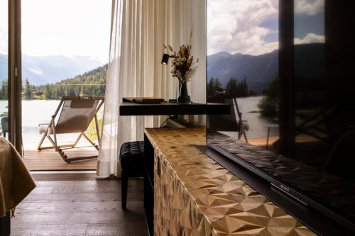 a room with a table and a large window with a view at Au Club Alpin in Champex