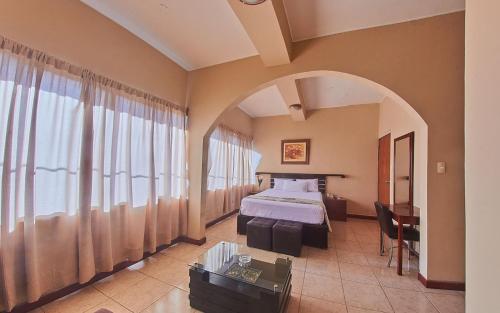 a hotel room with a bed and a table at Hotel America Pucallpa in Pucallpa