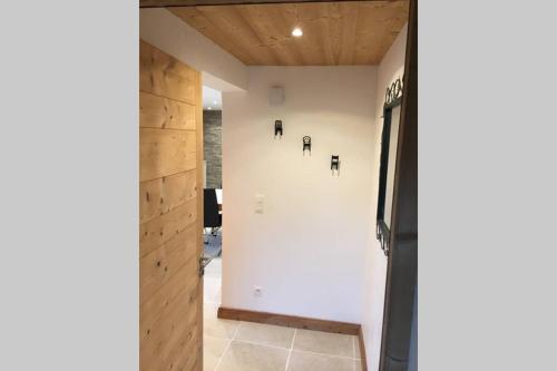 un couloir orné d'un mur blanc avec des photos. dans l'établissement la Télécabine studio 4 personnes, à Marnaz