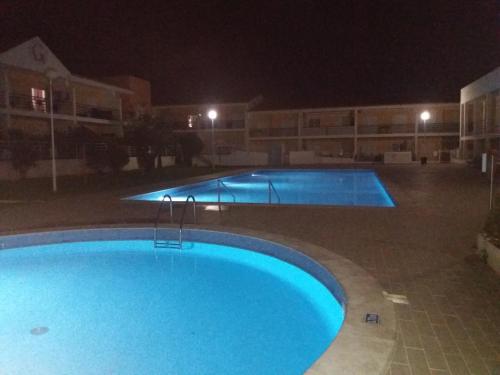 een groot zwembad 's nachts in een gebouw bij Encosta S. José -Vale Parra in Albufeira