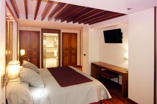 Dormitorio con cama, escritorio y TV en Casa Consistorial, en Fuengirola