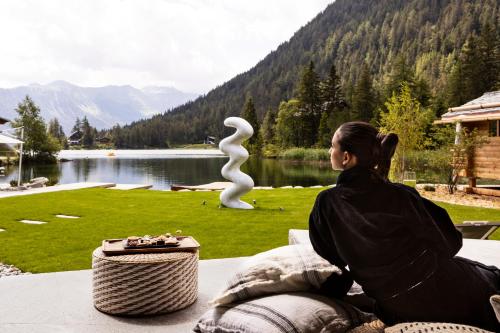 a woman sitting on a table looking at a sculpture at Au Club Alpin in Champex