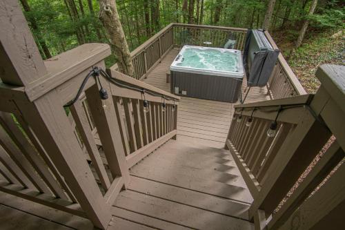 a wooden staircase with a hot tub on a deck at Tree House in Townsend