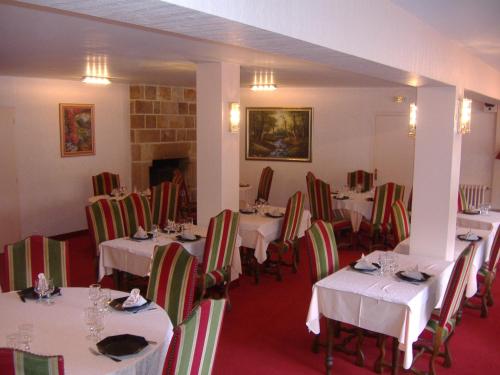 une salle à manger avec des tables et des chaises blanches dans l'établissement Auberge Pen Mur, à Muzillac
