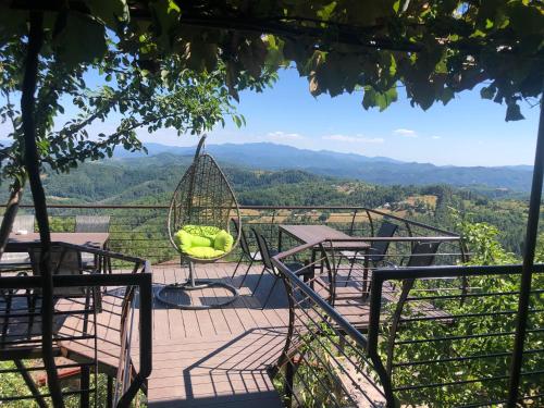a balcony with chairs and tables and a view of the mountains at Александрова вила 1 in Zlatograd