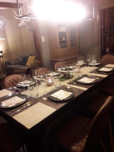 a long table with wine glasses and plates on it at Label Semois Gite rural 3 épis in Bouillon