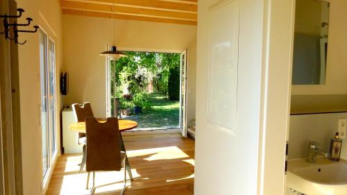 ein Esszimmer mit einem Tisch und einer Tür zum Hof in der Unterkunft Arwen in Uhldingen-Mühlhofen