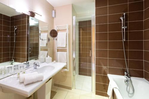a bathroom with two sinks and a shower at Hôtel Restaurant De La Poste & Du Lion D'or in Vézelay