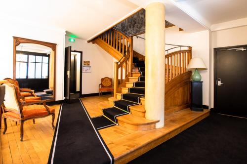 a living room with a staircase with a mirror at Hôtel Restaurant De La Poste & Du Lion D'or in Vézelay